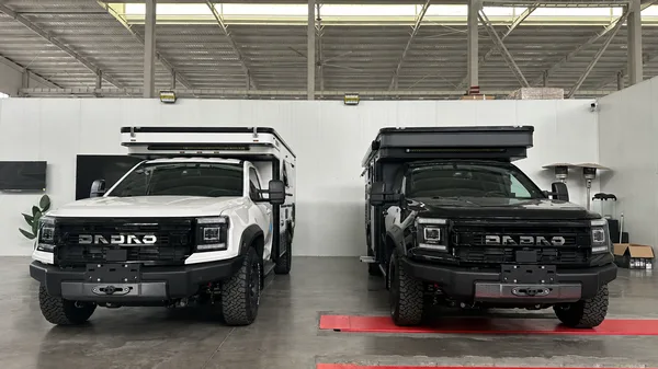 Two finished SUNHOMEE campers in the workshop showroom