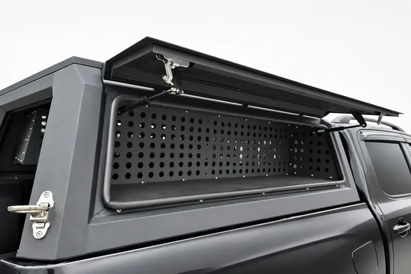 Truck topper side door open showing the perforated tool-box panel