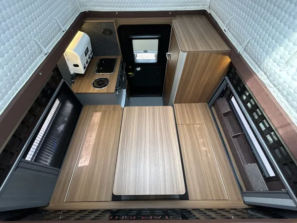 Camper interior with wood floor panels and kitchen unit, top view