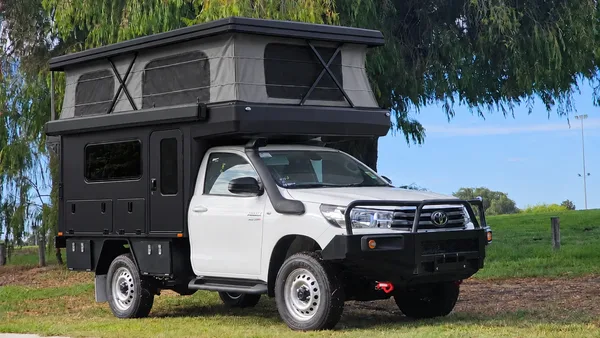 Toyota Hilux single cab with a black SUNHOMEE tray-mount camper