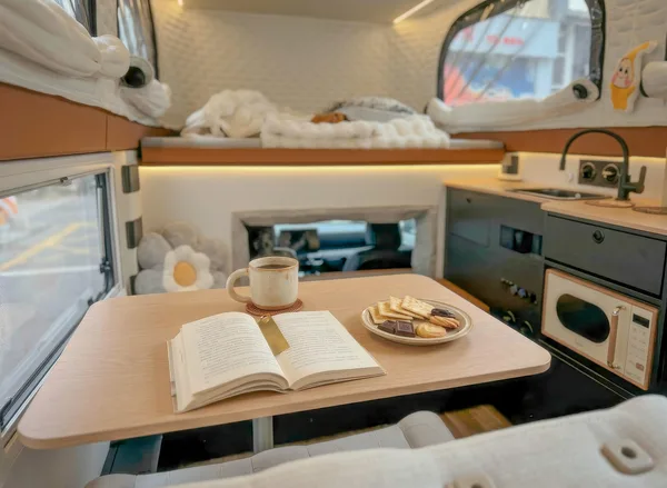 Reading at the dinette table inside the camper