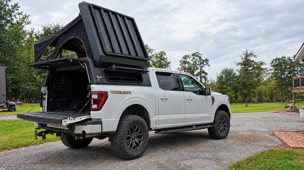 Stealth pop-up topper with the tent open on a white Ford F-150, rear three-quarter view