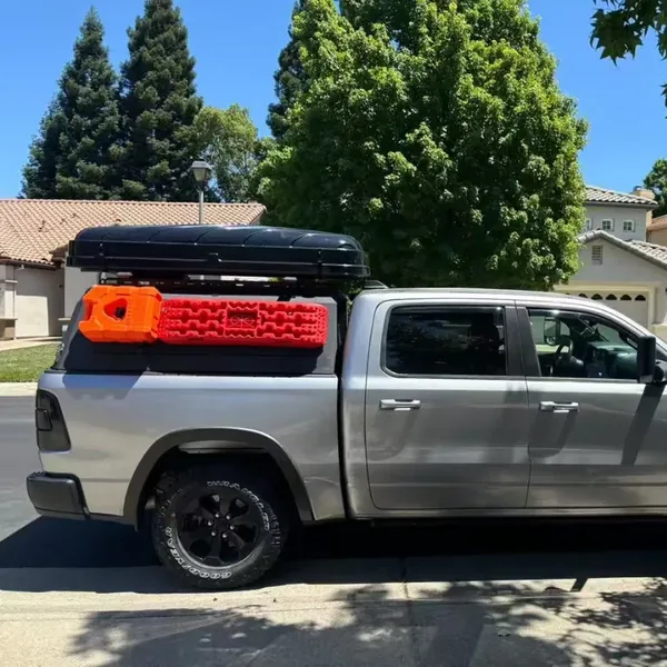Silver RAM 1500 with a SUNHOMEE truck topper and roof-mounted tent